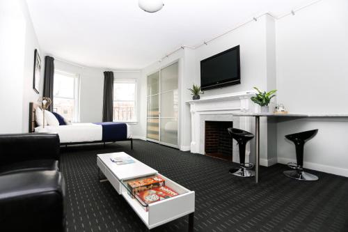 a living room with a bed and a fireplace at Charming Studio on Boston's Iconic Newbury St. #8 in Boston