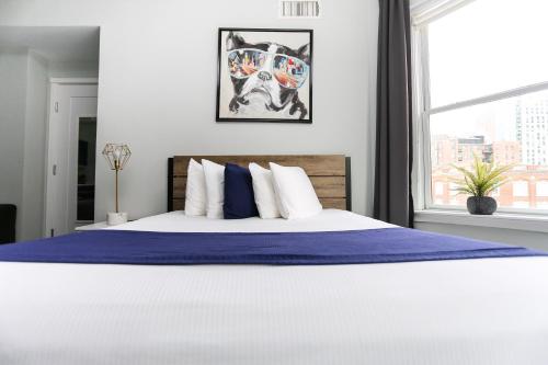a bed with a blue blanket and a window at Charming Studio on Boston's Iconic Newbury St. #8 in Boston