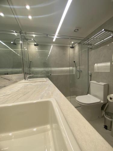 a bathroom with a bath tub and a toilet at Ninety Suíte Premium in Sao Paulo