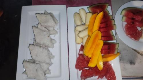 a plate of food with fruit and vegetables on it at Jaana Guest in Sigiriya