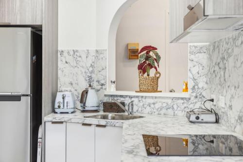 a white kitchen with a sink and a refrigerator at Sea Tonic on Market in Woolgoolga