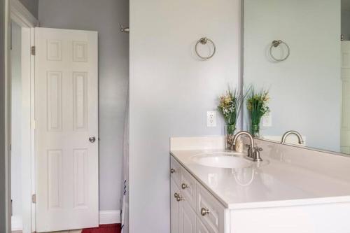 a white bathroom with a sink and a mirror at Private room balcony and bathroom in Charleston in Charleston