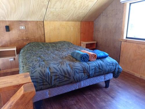 ein kleines Schlafzimmer mit einem Bett in einer Hütte in der Unterkunft Cabaña Valdivia Piedra Blanca 2 in Valdivia