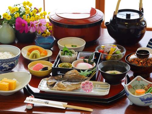 a table with various dishes of food on it at 水と緑のやすらぎの宿　一の瀬 in Mishima