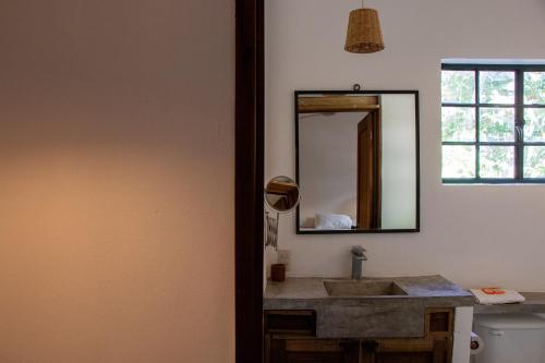 uma casa de banho com um lavatório e um espelho em Soiree em Zipolite