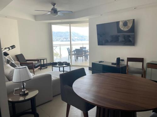 sala de estar con sofá y mesa en Bay View Grand Marina Ixtapa condo en pie de playa en Ixtapa