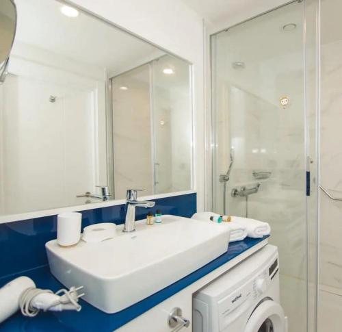 uma casa de banho com um lavatório branco e um chuveiro em Queen apartments in batumi em Batumi