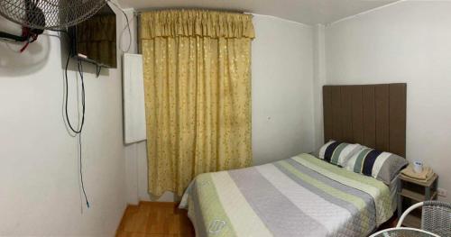 1 dormitorio con cama y cortina amarilla en Huacachina Sunset, en Ica