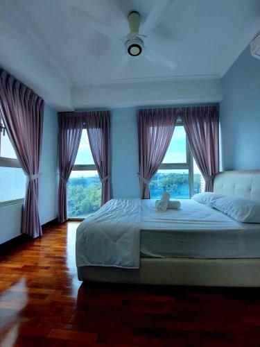 una camera da letto con un grande letto con tende viola di Suria Homes a Shah Alam
