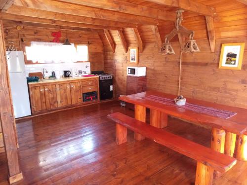 a kitchen with wooden floors and a table in a cabin at La Montañesa in Epuyén