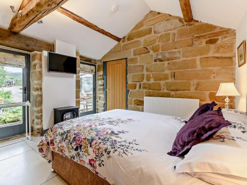 a bedroom with a bed and a stone wall at 1 Bed in Helmsley 93100 in Chop Gate