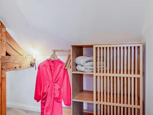 Eine rote Jacke hängt auf einem Regal in einem Zimmer. in der Unterkunft 2 Bed in Warwick 93085 in Warwick