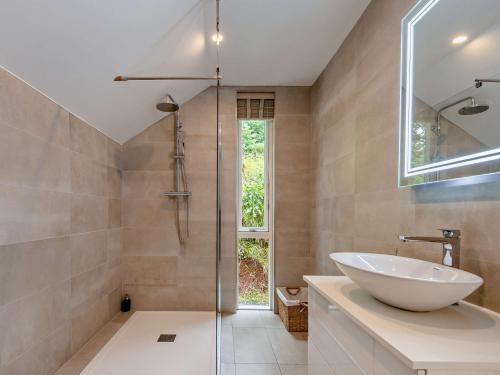 ein Bad mit einem Waschbecken und einer Glasdusche in der Unterkunft 1 Bed in Totnes 93061 in Marldon