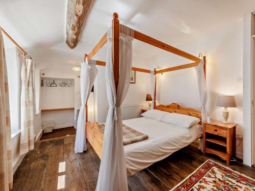 una camera con letto a baldacchino e pavimento in legno di 2 Bed in Machynlleth 93082 a Cemmaes