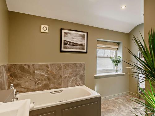 a bathroom with a tub and a window at 2 Bed in Leyburn 93162 in Leyburn