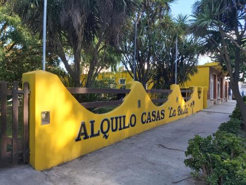 a yellow fence with a sign that reads alula casas taxatown at Chapadmalal Casas La Bella in Colonia Chapadmalal