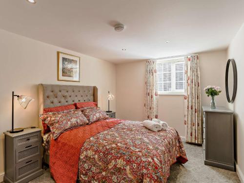 a bedroom with a bed with a red comforter and a window at 1 Bed in Bingley 91492 in Wilsden