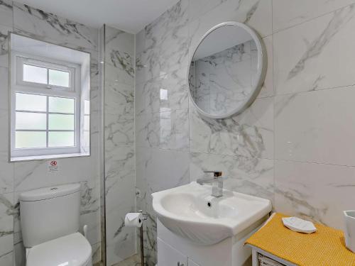 uma casa de banho branca com um lavatório e um espelho em 1 Bed in Bingley 91492 em Wilsden