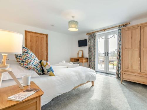 Un dormitorio con una gran cama blanca y una ventana en 3 Bed in Newquay 89943 en Mawgan Porth
