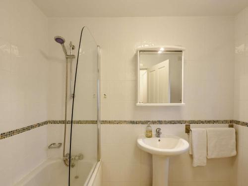 a white bathroom with a sink and a shower at 3 Bed in Arnside and Silverdale 90531 in Beetham