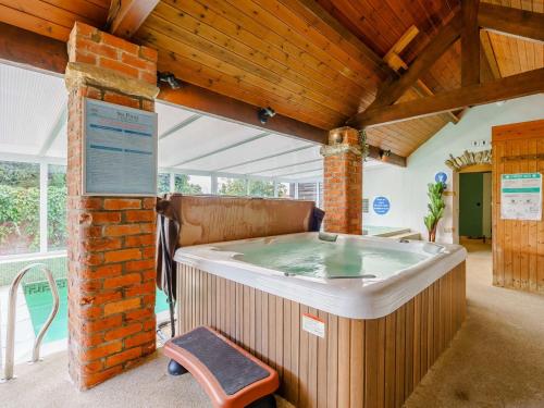 uma banheira de hidromassagem num quarto com tecto em madeira em 2 Bed in Pickering 88955 em Newton