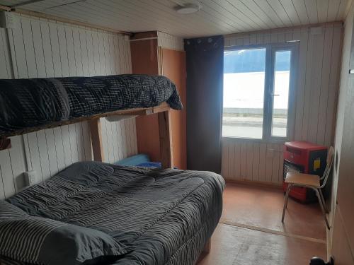 a bedroom with two bunk beds and a window at Refugio Jemmy Button in Puerto Williams
