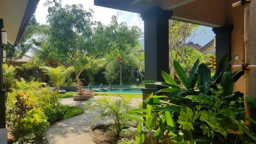 a garden with a swimming pool and plants at Doubleyou Homestay Pemuteran in Pemuteran