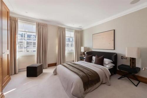 een grote slaapkamer met een groot bed en ramen bij ARCORE Premium Apartments Eaton Place in Londen