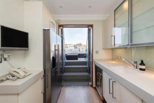 een keuken met een wastafel en een deur naar een kamer bij ARCORE Premium Apartments Eaton Place in Londen