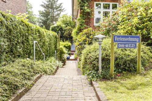 a street sign in front of a house with a sign at Immenhof in Flensburg