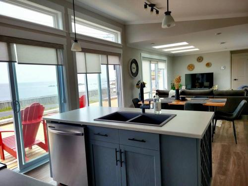 2 Bedroom 2 Bathroom Oceanfront Oasis في بونافيستا: مطبخ مع حوض وغرفة معيشة