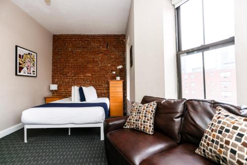 een woonkamer met een bank en een bed bij Stylish Studio in Boston Brownstone, C.Ave #21 in Boston