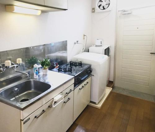 a small kitchen with a sink and a refrigerator at Best Room In Kawagoe 5 in Kawagoe