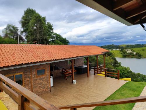 une maison avec une terrasse donnant sur un lac dans l'établissement Chácara Igaratá Pé na Água Recanto Sol & Ariluma, à Igaratá