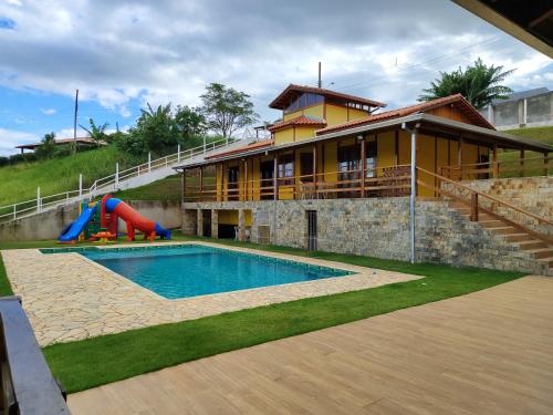 uma casa com piscina em frente a uma casa em Chácara Igaratá Pé na Água Recanto Sol & Ariluma em Igaratá