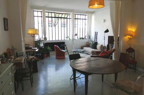 uma sala de estar com mesa e cadeiras em Quiet and spacious 90 m loft in Bagnolet em Bagnolet