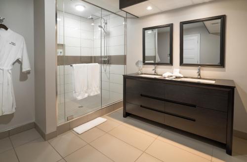 La salle de bains est pourvue d'un lavabo et d'une douche. dans l'établissement Auberge des Gallant, à Rigaud