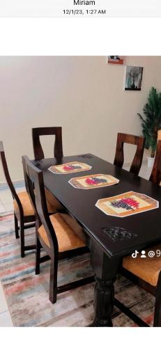 a black dining room table with four chairs around it at 3RD Ave. Beach Apartment Nyali, Mombasa, North Coast in Nyali