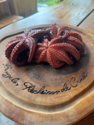 a cake with an octopus on a wooden plate at Bangalôs Flecheiras de Canaã in Flecheiras