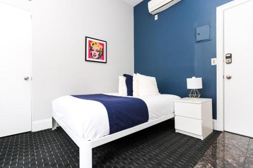 1 dormitorio con 1 cama con pared azul en Stylish Downtown Studio in the SouthEnd, C.Ave #24, en Boston