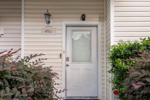 Eine weiße Tür an einem Haus mit einem Schild drauf. in der Unterkunft Private room and bathroom in Charleston, SC in Charleston