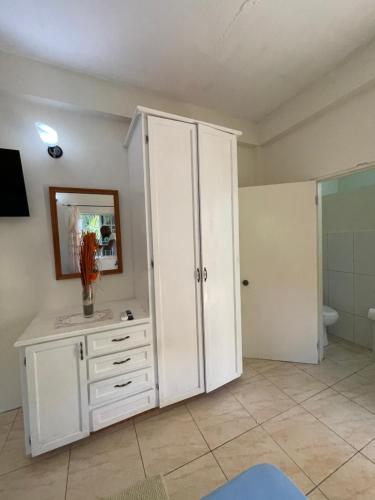 Cette chambre comprend une armoire blanche et une salle de bains. dans l'établissement Evergreen, à Kingstown