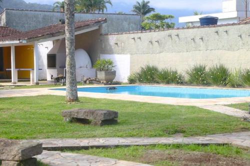 a yard with a swimming pool and a house at Villa Tavares - casa com piscina na praia da Lagoinha in Ubatuba