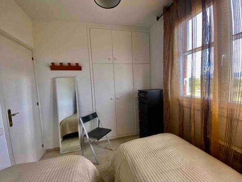 a bedroom with two beds and a chair and a window at Lovely house in Bellaterra (10 min to UAB) in Cerdanyola del Valles