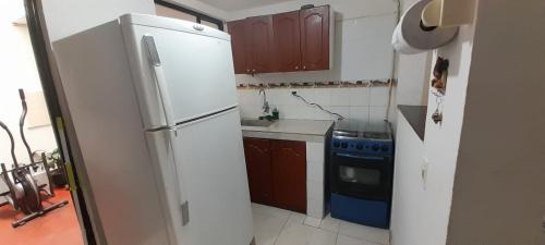 a kitchen with a white refrigerator and a stove at Casa Blanca in Ibagué