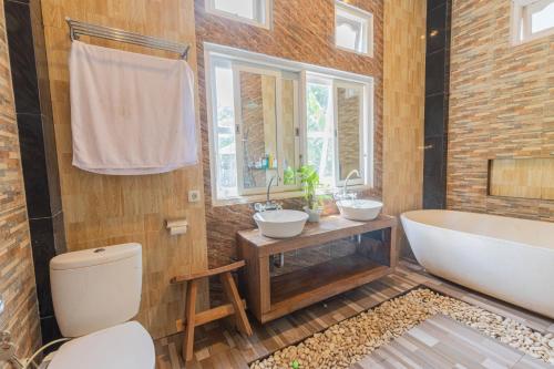 La salle de bains est pourvue de 2 lavabos et d'une baignoire. dans l'établissement Amartha Indotama Guest House, à Tjepit
