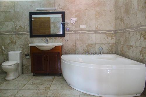 La salle de bains est pourvue d'une baignoire, d'un lavabo et de toilettes. dans l'établissement Camellia Rise, à Kandy