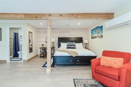 a bedroom with a bed and a red chair at Palm Studio Apartment near Lake Hollingworth in Lakeland