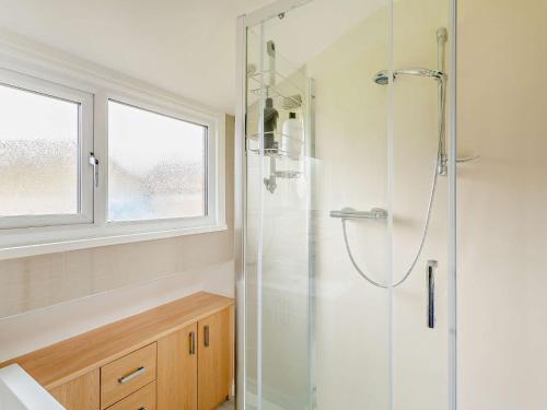 a bathroom with a shower with a glass door at 3 Bed in Pateley Bridge 93305 in Summer Bridge