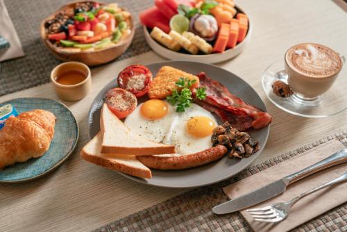 a plate of breakfast food with eggs bacon and toast at Maison Aurelia Sanur, Bali - By Préférence in Sanur